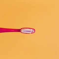 Różowa szczoteczka z biało-fioletową pastą. Uważaj na połknięcie pasty do zębów skutki mogą być nieprzyjemne.