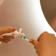 RDA co to? Dłoń wyciska pastę na szczoteczkę do zębów.