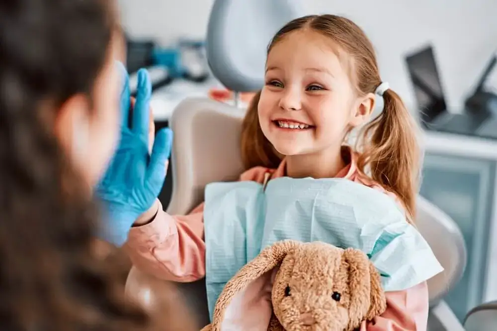 dziecko na kolanach rodzica u dentysty