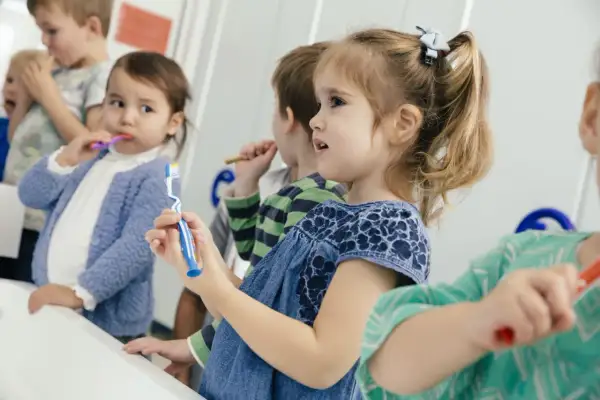 Dzieci myją zęby w szkole. Czy fluoryzacja w szkole tak czy nie? Dbają o uśmiechy.
