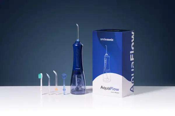 Zestaw do higieny jamy ustnej: niebieski irygator Smilesonic AquaFlow z kilkoma końcówkami i pudełkiem. Jaka woda do irygatora? Czysta woda lub płyn do płukania.